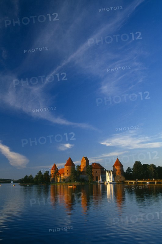 LITHUANIA, Trakai, "Wide angle view of castle reflected in lake with windswept clouds above,"