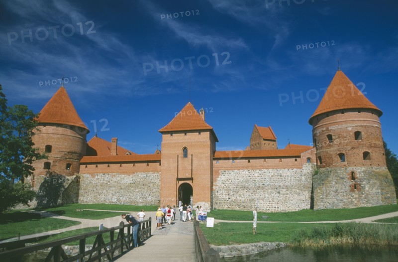 LITHUANIA, Trakai, Visitors on bridge to entrance of Trakai Castle.
