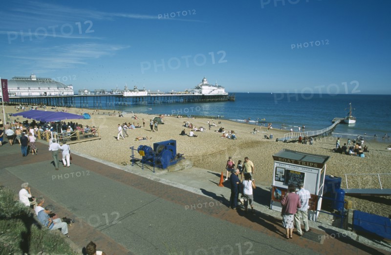 ENGLAND, East Sussex, Eastbourne, View from promenade across busy beachfront and pier.