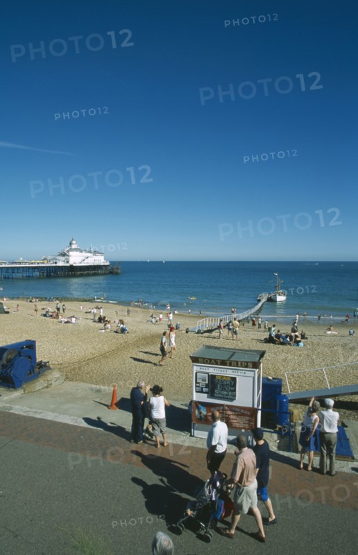 ENGLAND, East Sussex, Eastbourne, View from promenade across busy beachfront and pier.