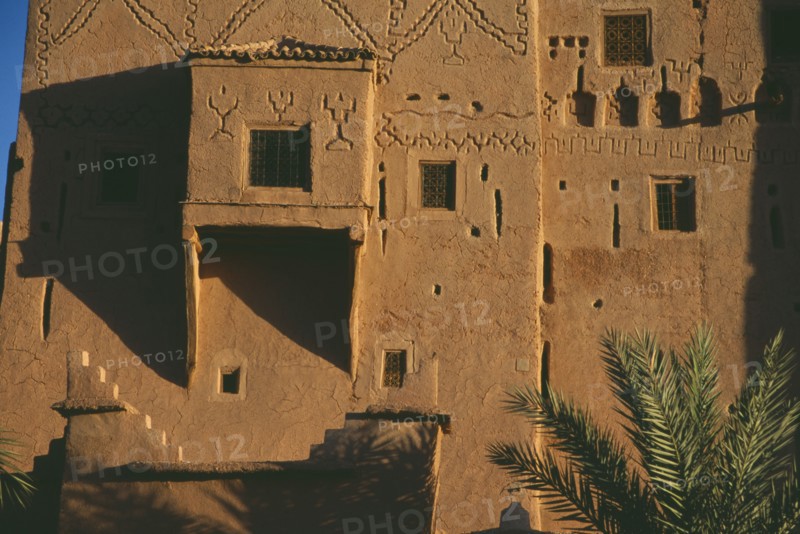 MOROCCO, Ouarzazate, Kasbah Taorirt .  Nineteenth century kasbah of the el-Glaoui dynasty.  Detail of exterior wall with simple decoration and small windows with metal screens.