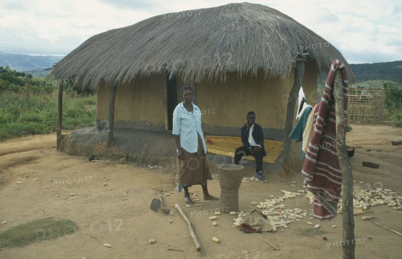 MALAWI, Lumbe, Couple outside thatched home in Wilsan village.