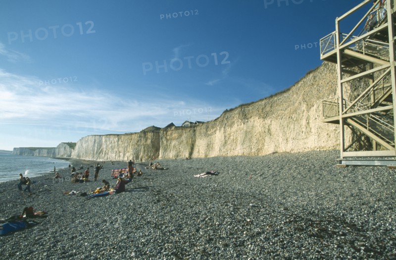 ENGLAND, East Sussex, Birling Gap, Occupied stretch of pebble beach at the cliff base with the stair construction on the right.