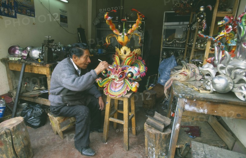BOLIVIA, La Paz, Man in a workshop working on a mask.