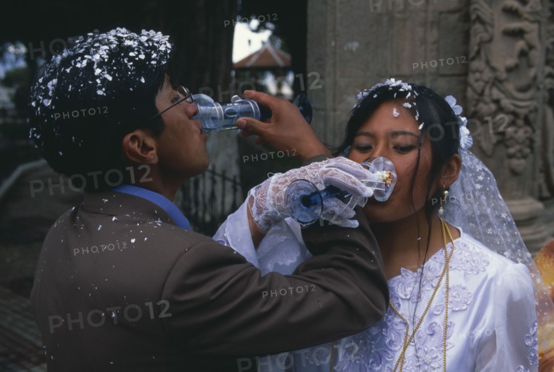 BOLIVIA, La Paz, Wedding in El Monticulo. Bride and Groom interlocking arms and drinking.