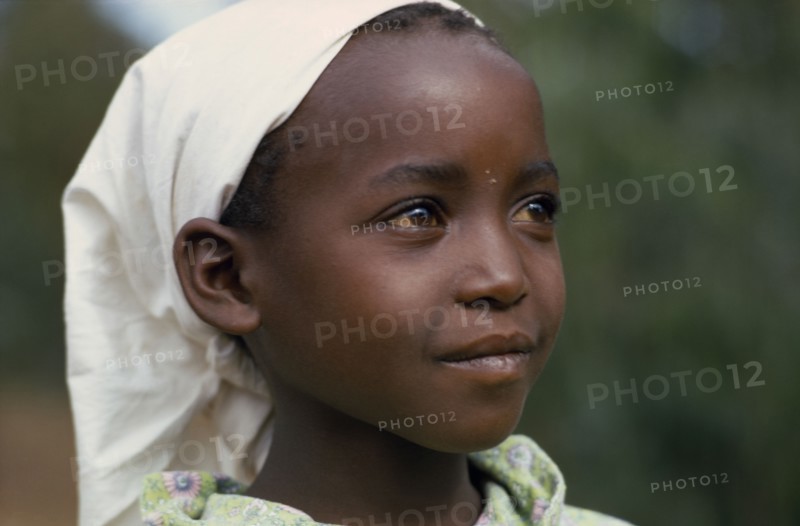 KENYA, Tribal People, "Head and shoulders portrait of young Kikuyu girl wearing headscarf, three quarter profile right."