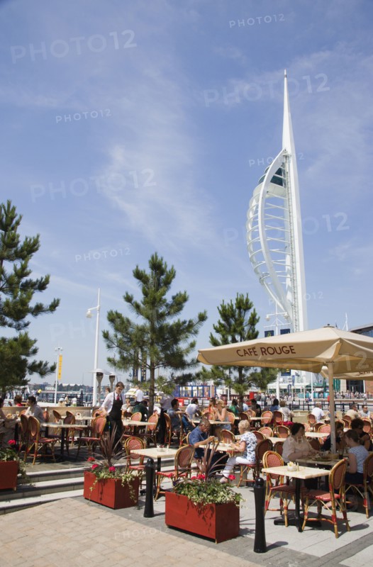 ENGLAND, Hampshire, Portsmouth, The Spinnaker Tower the tallest public viewing platforn in the UK at 170 metres on Gunwharf Quay with outdoor restaurant seating in the foreground