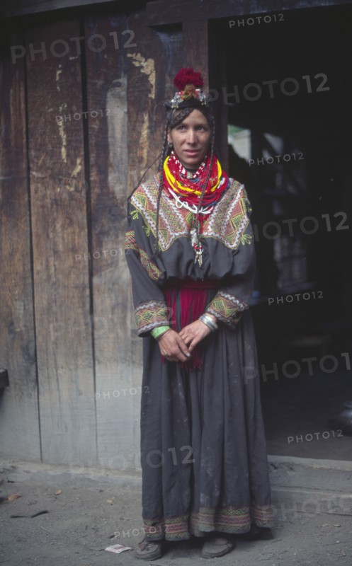 PAKISTAN, North West Frontier Province, Rumbur valley, "Kalash woman standing, wearing traditional dress."