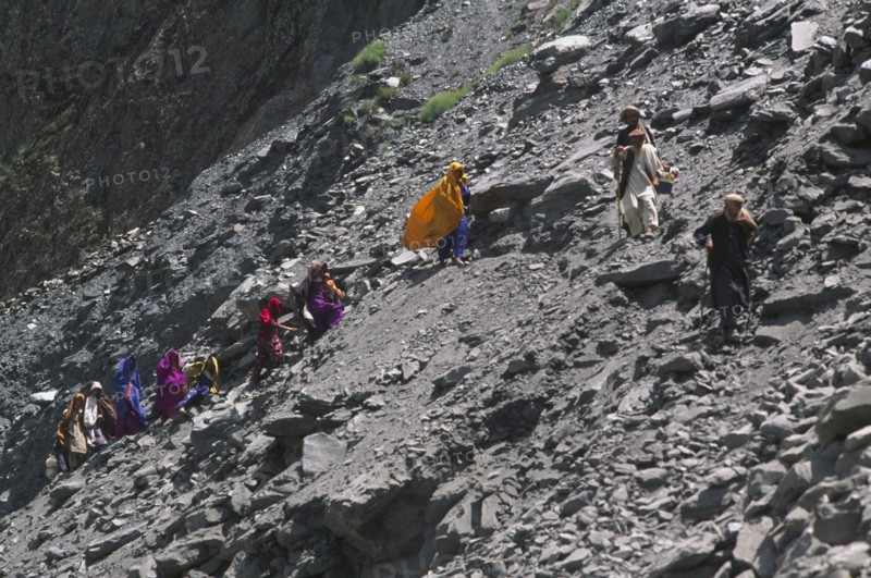 PAKISTAN, North West Frontier Province, Group of travellers negotiating a land slide on the Karakorum Highway.