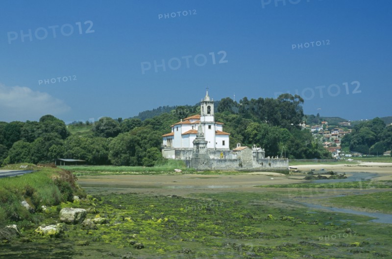 SPAIN, Asturias, Barro, Traditional white church with bell tower and graveyard. Building alone in a field.