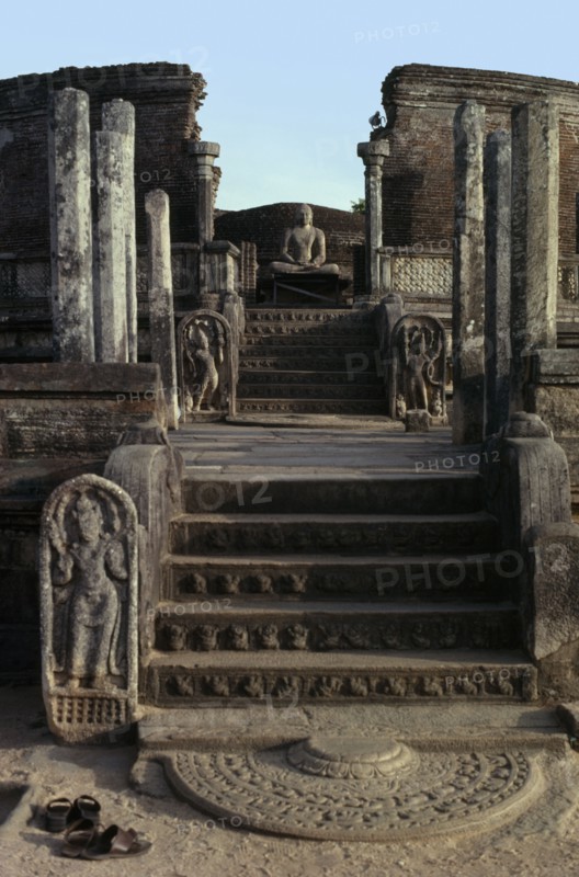 SRI LANKA, Polonnaruwa, Vatadage circular relic house.  Moonstone or carved stone doorstep at the northern entrance with seated Buddha figure beyond.