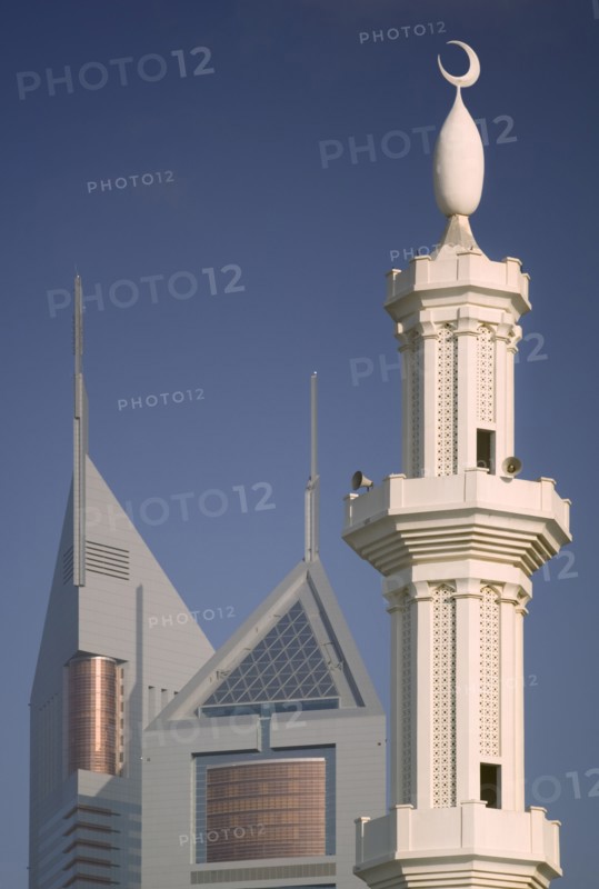 UAE, Dubai, The Emirates Towers with a minaret in the foreground.