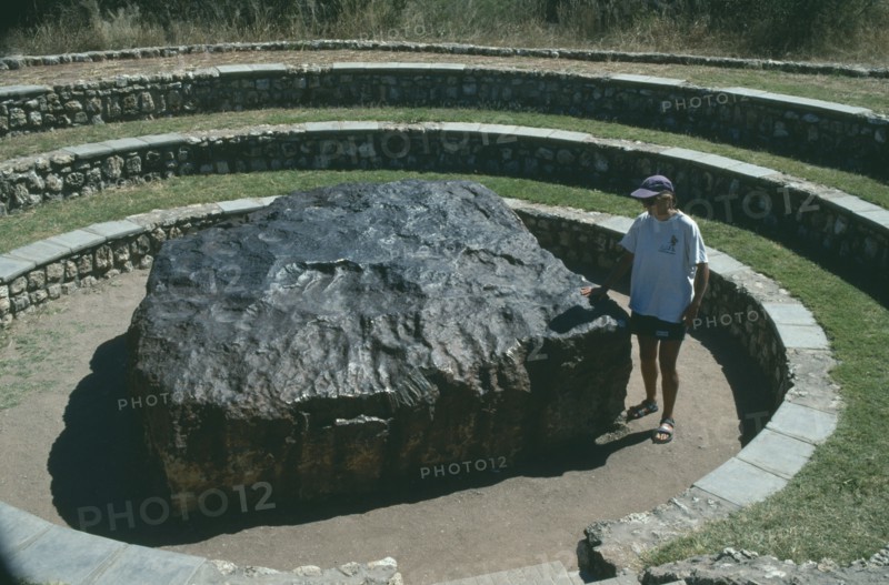 NAMIBIA, Hoba Meteorite, "Largest in the World, woman standing next to it."
