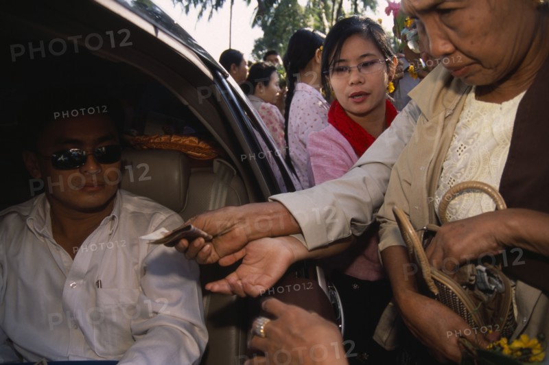 MYANMAR, Yangon, Donations being made to revered monk at Shwedagon Pagoda.