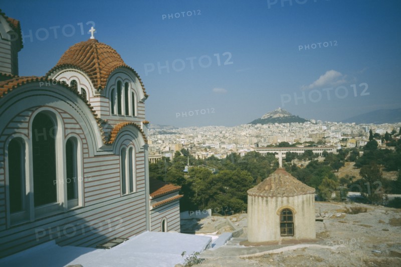 GREECE, Central, Athens, View of a church in the foreground and Acropolis and Lykavitos in the distance.
