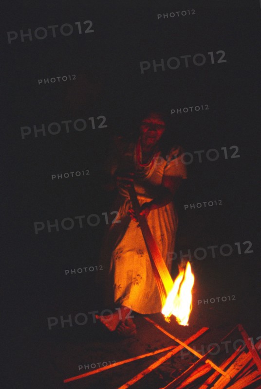 COLOMBIA, Vaupes, Tukano Indian woman lighting a fire.