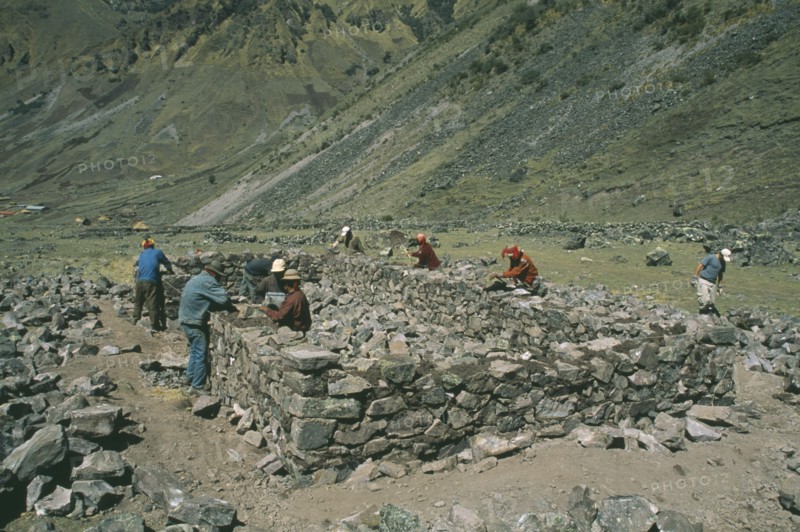 PERU, Cusco, Cancha Cancha, Local Quechuan men building a house.