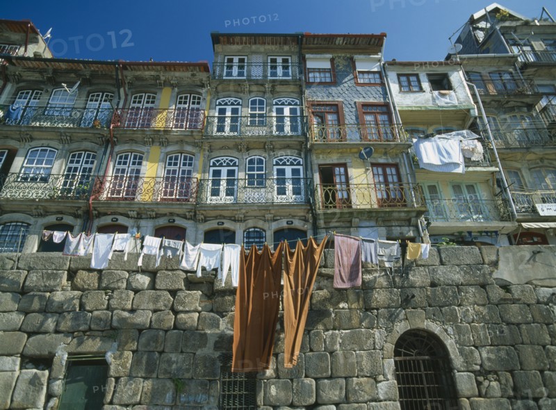 PORTUGAL, Porto, Oporto, Washing hanging from walls and balconies of waterfront houses in the Ribeira riverside quarter.