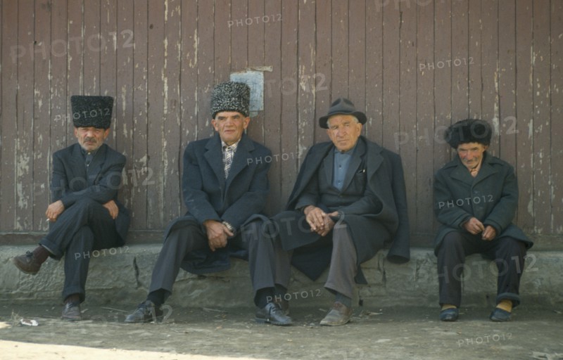 RUSSIA, Dagestan, Koubachi, ‘Gooderan’ meeting place.  Four men sitting along wall.