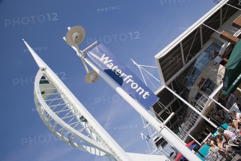 ENGLAND, Hampshire, Portsmouth, The Spinnaker Tower the tallest public viewing platforn in the UK at 170 metres on Gunwharf Quay with people sitting at tables outside waterfront restaurants