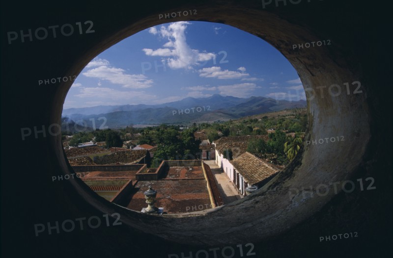 CUBA, Trinidad, View across red tiled city rooftops framed by oval window in Iglesia San Franciso de Paula.