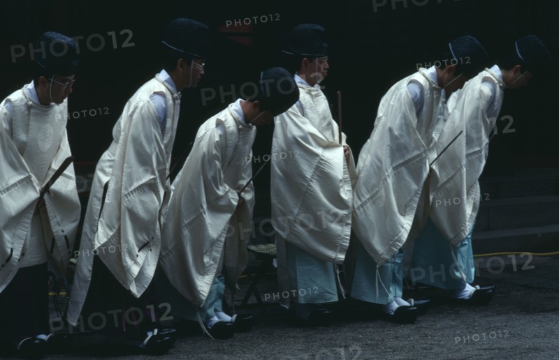 JAPAN, Honshu, Tochigi, Nikko.  Shinto priests watch and bow as the omikoshi or residence of the local kami or deity is carried past at Futara-gu Jinga during the Tosho-gu festival.