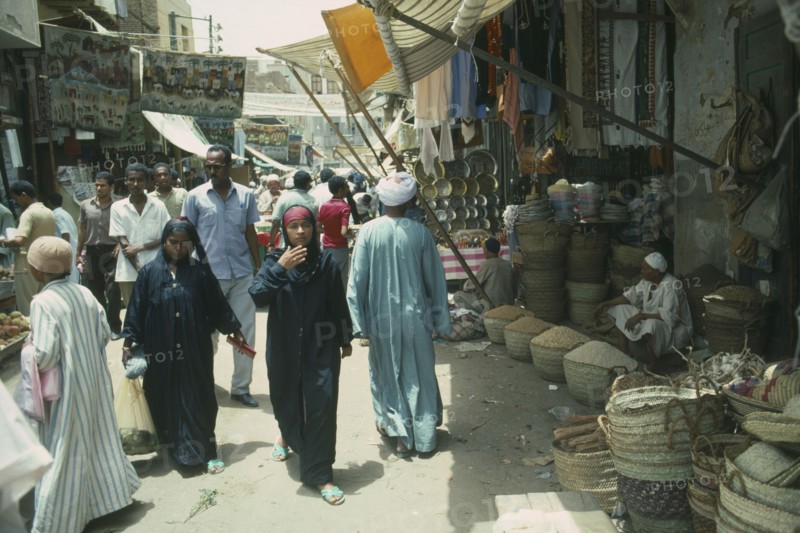 EGYPT, Aswan, Busy souk market scene with pulse vendor and crowds walking by.
