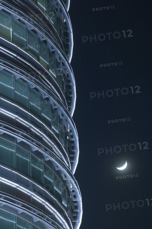 MALAYSIA, Peninsular, Kuala Lumpur, Detail of the Petronis Towers at night with a crescent moon behind.
