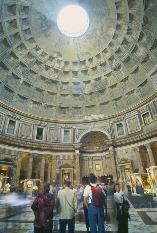 ITALY, Lazio, Rome, "Pantheon.  Interior of Roman temple, visitors looking up at circular opening or oculus in domed ceiling leeing in beam of light."