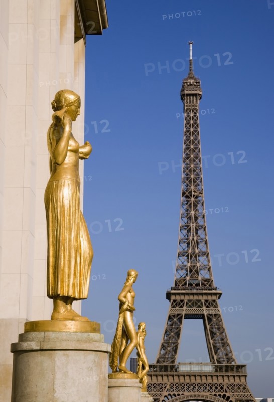 FRANCE, Ile de France, Paris, Gilded bronze statues in the central square of the Palais de Chaillot with the Eiffel Tower beyond
