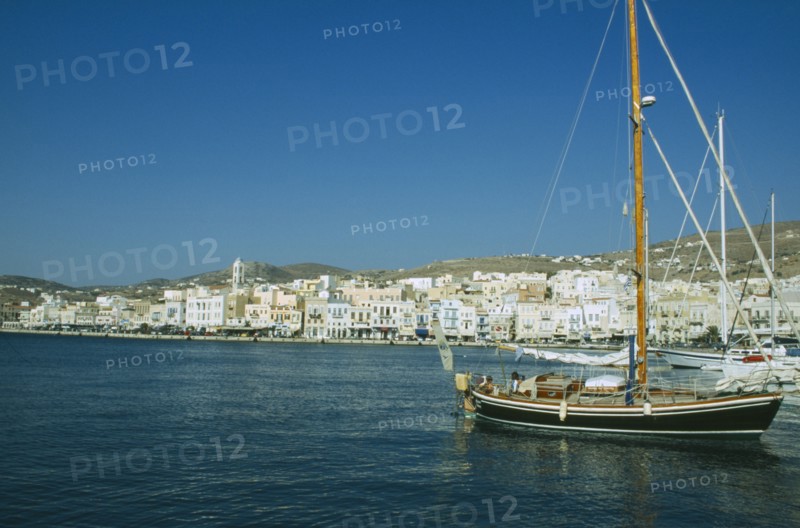GREECE, Cyclades Islands, Syros, Ermoupolis. Sailing boats in the port with view of the seaside town.
