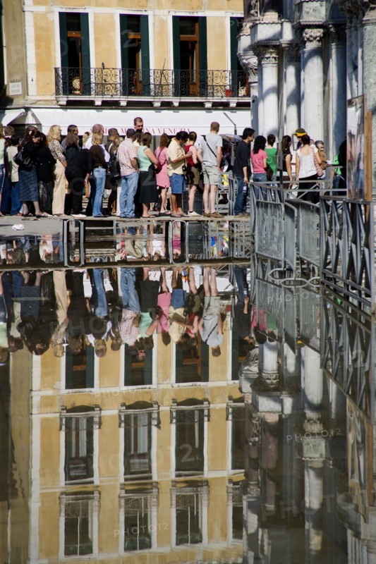 ITALY, Veneto, Venice, Aqua Alta High Water flooding in St Marks Square with tourists queuing on elevated walkways to enter St Marks Basilica