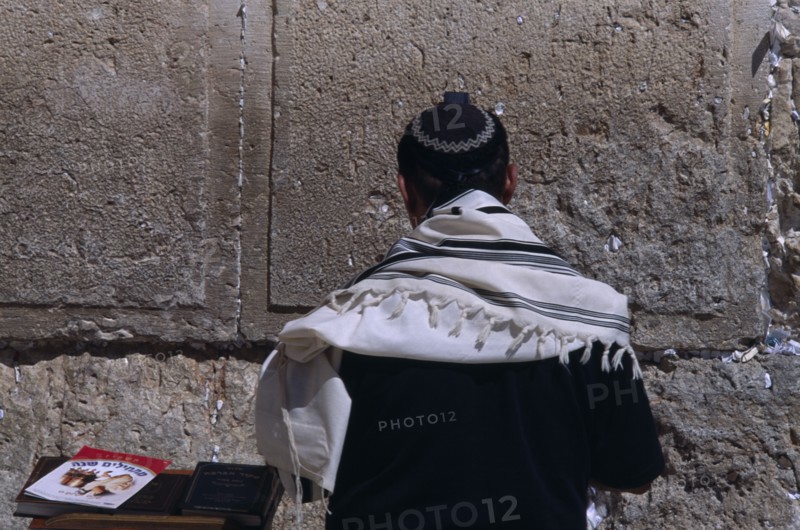 ISRAEL, Jerusalem, A Jewish man wearing a traditional prayer shawl praying at the Western Wall.