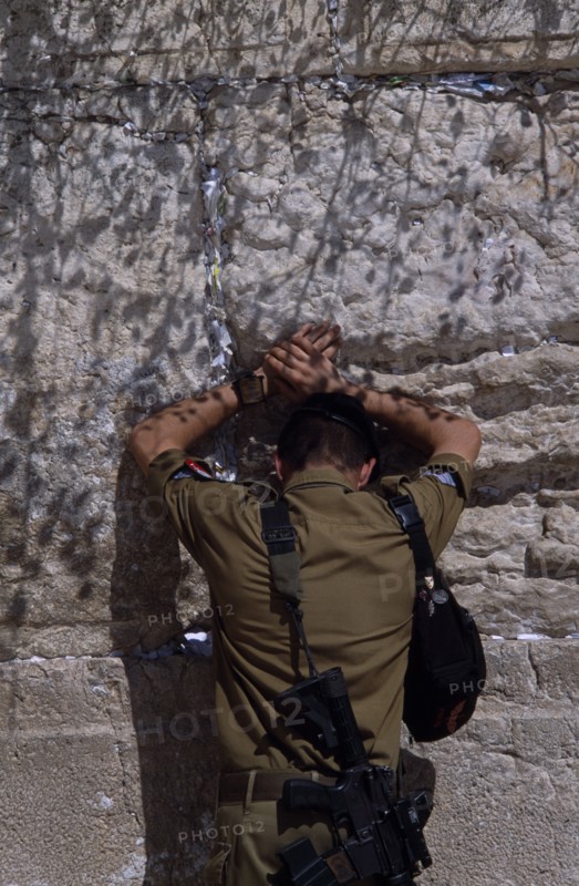 ISRAEL, Jerusalem, An Israeli Soldier in army uniform with a M16 Assault Riffle around his shoulder praying at The Western Wall