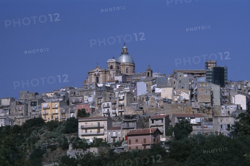 ITALY, Sicily, Enna, Piazza Armerina. Hilltop town buildings with a church dome at the top