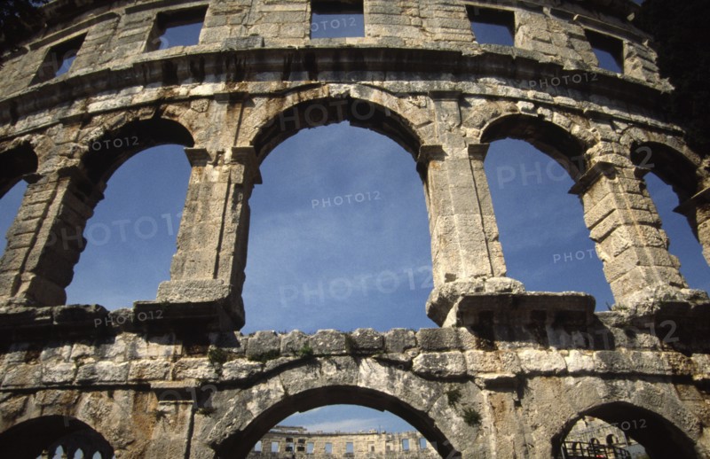 CROATIA, Istria, Pula, "Arches of Roman Arena, built towards the end of the 1st century BC. Capable of seating 22,000 Roman spectators, it is the sixth largest amphitheatre in the world. Today it retains its original purpose as a venue for entertainments, housing a series of summer concerts every year."