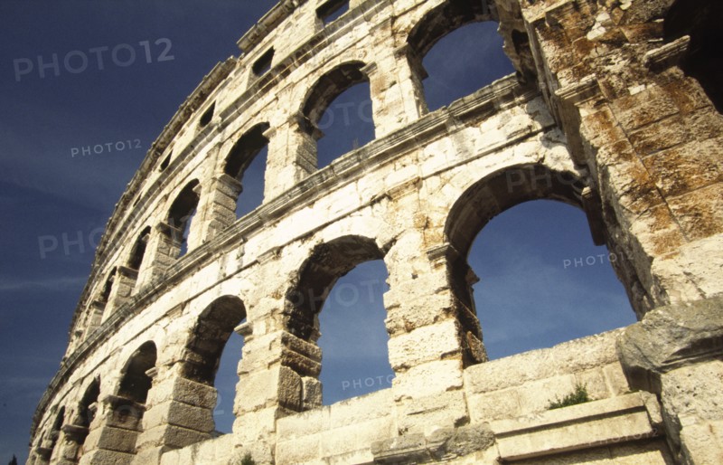CROATIA, Istria, Pula, "Arches of Roman Arena. Built towards the end of the first century BC, the Arena is the sixth largest of its kind in the world and one of the best preserved. Once capable of seating 22,000 Roman spectators, it still retains its place as an entertainment venue, housing concerts throughout the summer months."