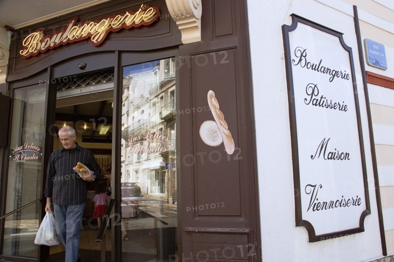 FRANCE, Aquitaine Pyrenees Atlantique, Biarritz, The Basque seaside resort on the Atlantic coast. Man leaving boulangerie bakery with baguettes under his arm in the commercial centre of the town.