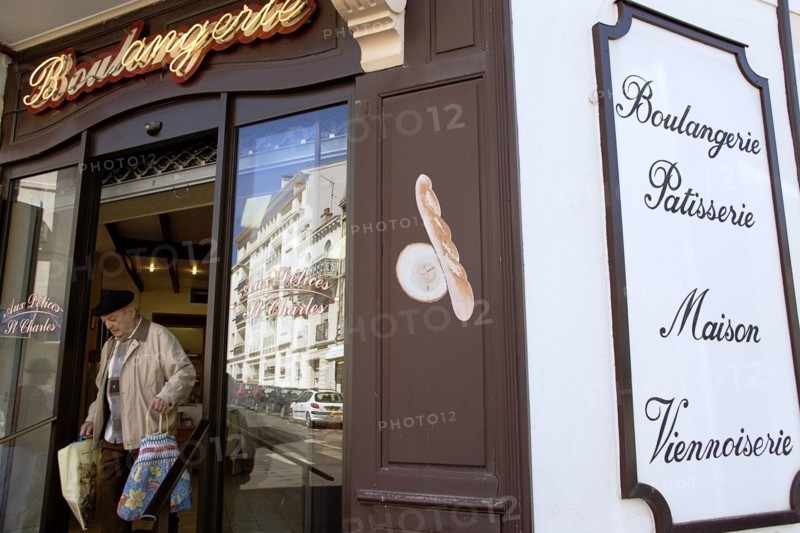 FRANCE, Aquitaine Pyrenees Atlantique, Biarritz, The Basque seaside resort on the Atlantic coast. Man leaving boulangerie bakery with bread in bags in the commercial centre of the town.