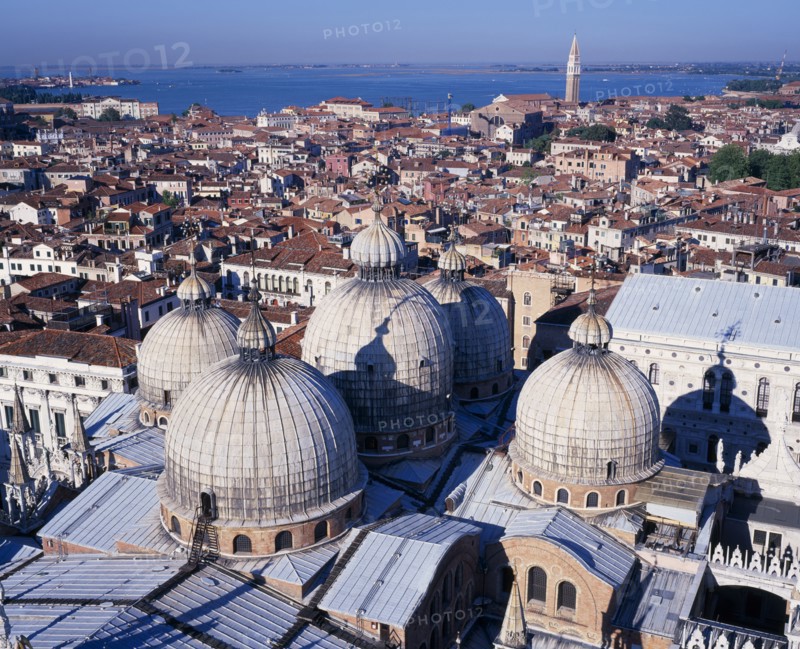 ITALY, Veneto, Venice, View from the Campanile over domed rooftops of St Mark’s Basilica and city beyond.