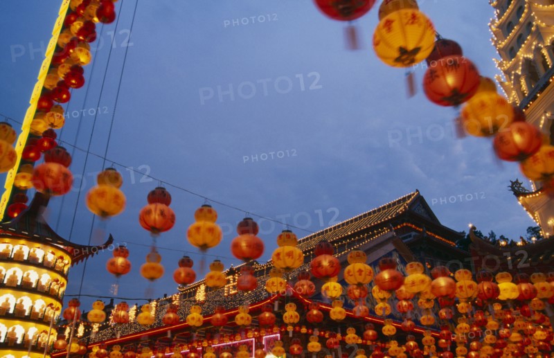 MALAYSIA, Penang, Kek Lok Si Temple, Temple roof decorated with lights and hung with red and yellow Chinese lanterns at Chinese New Year.
