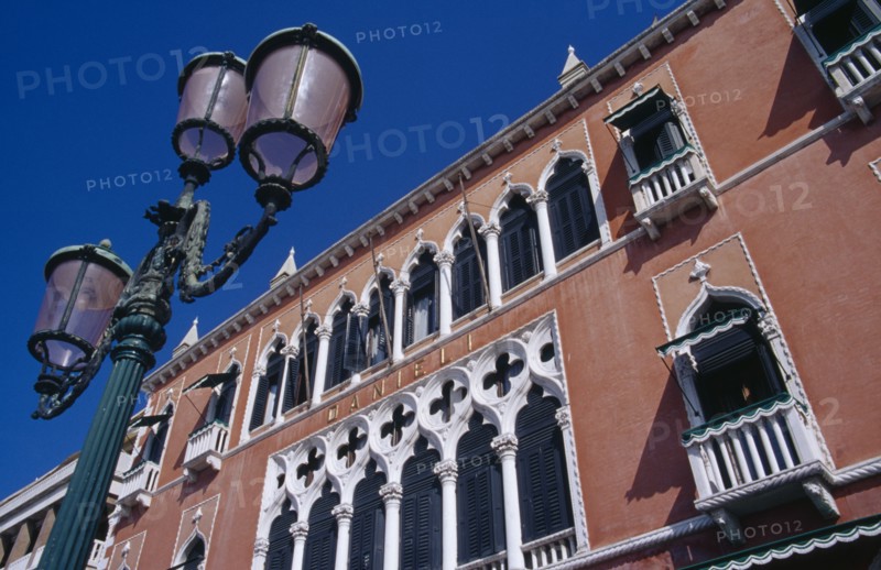 ITALY, Veneto, Venice, Terracotta and white painted facade of the Danieli Hotel with street lamp in foreground.