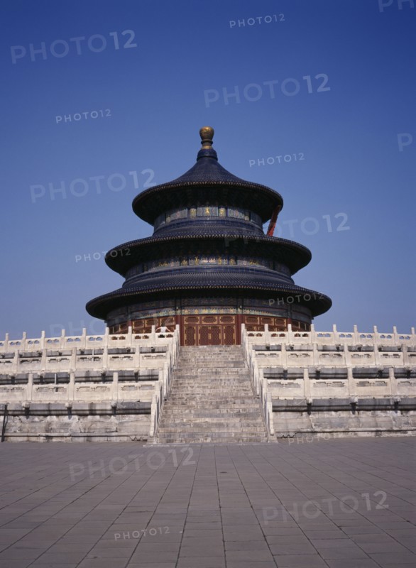CHINA, Beijing, Temple of Heaven.  Hall of Prayer for Good Harvests with western tourist standing at top of steps to entrance.