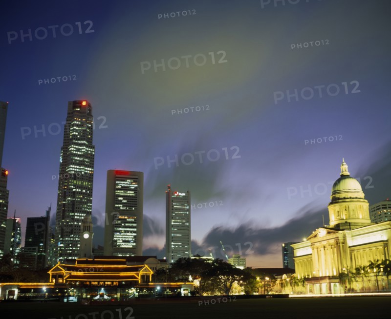 SINGAPORE, Raffles Place, Illuminated skyline of Raffles Place at dusk from Padang.