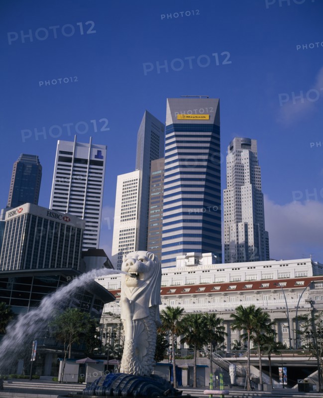 SINGAPORE, Raffles Place, Merlion fountain in front of The Fullerton Hotel with highrise banks and office buildings behind.