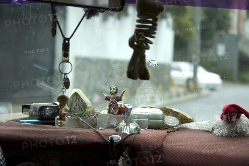 VENEZUELA, Caracas , "Dashboard of Caracas taxi including religious artefacts, a comb and reading glasses."