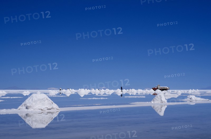 BOLIVIA, Potosi, Salar de Uyuni, Salt flats with salt piled up ready to be collected by truck.