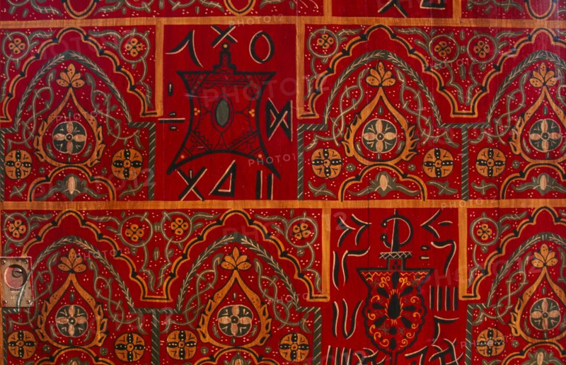 MOROCCO, Essaouira, Detail of red door painted with repeated pattern.