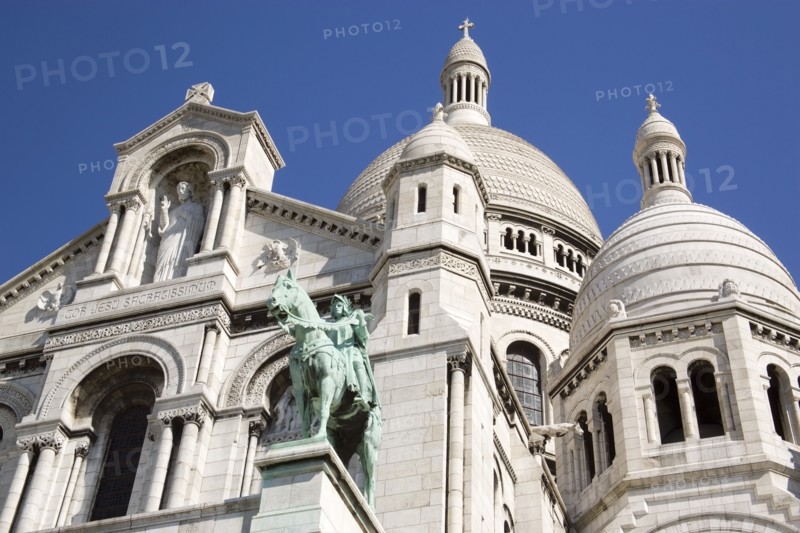 FRANCE, Ile de France, Paris, Montmartre The Church of Sacre Coeur or Sacred Heart with the bronze equestrian statue of Joan of Arc in the foreground