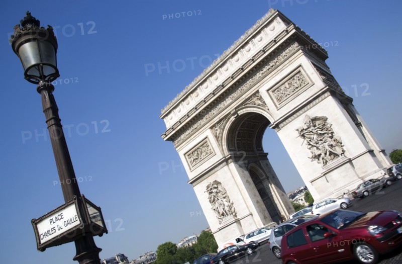 FRANCE, Ile de France, Paris, Traffic around the Arc de Triomphe in Place Charles de Gaulle with a street sign on a lamp post